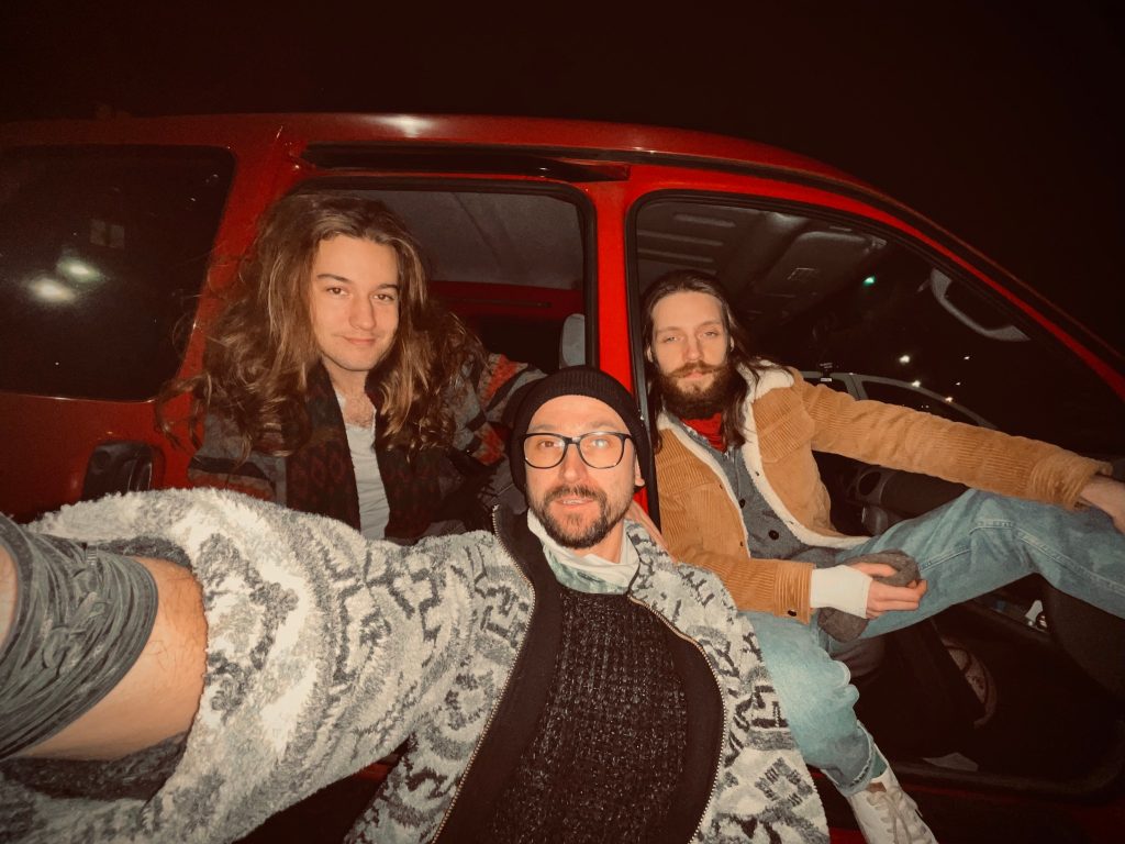 Zdjęcie 3 muzyków zespołu wysiadających z busa.